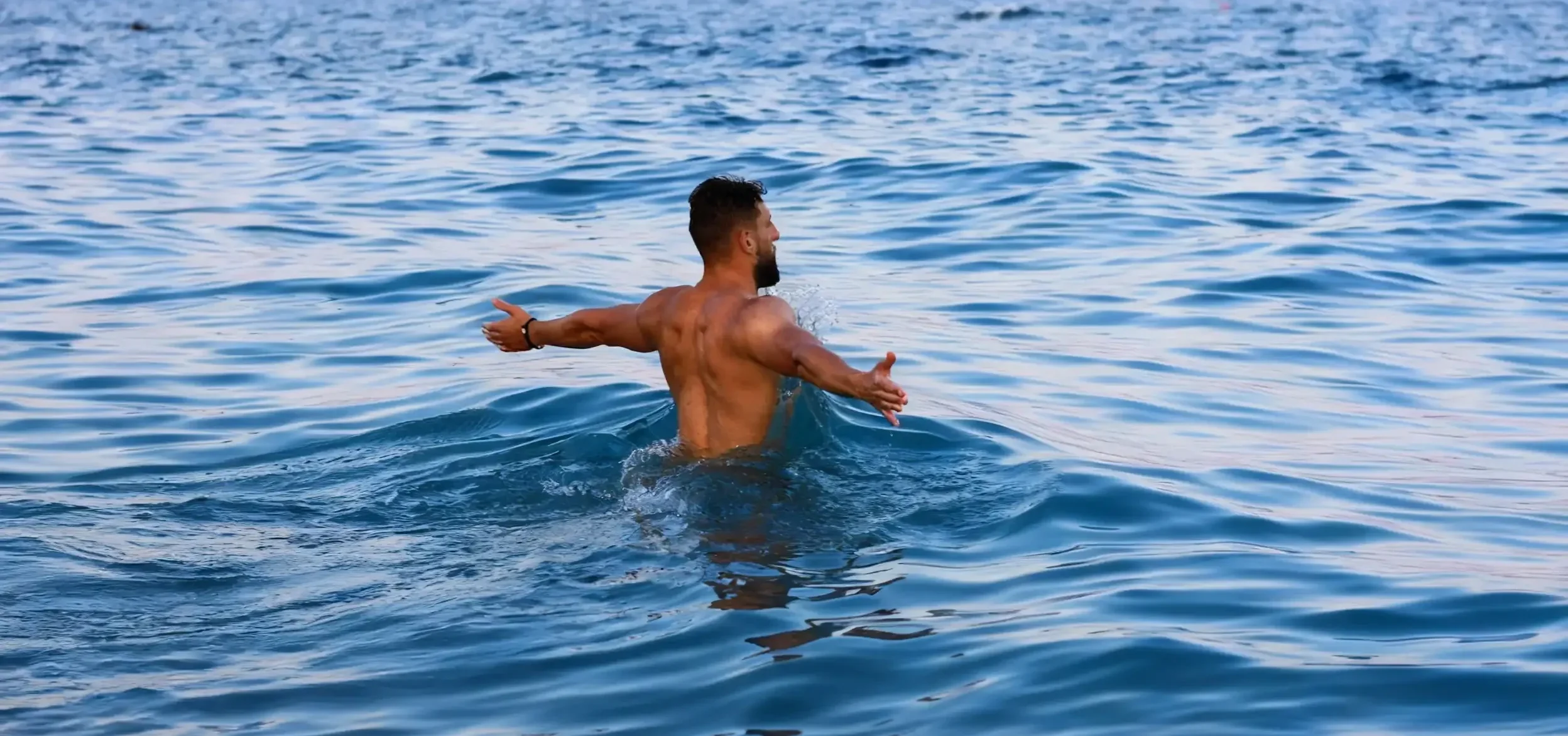 Fitness Coach beim Schwimmen im Meer - Regeneration im Personal Training Online