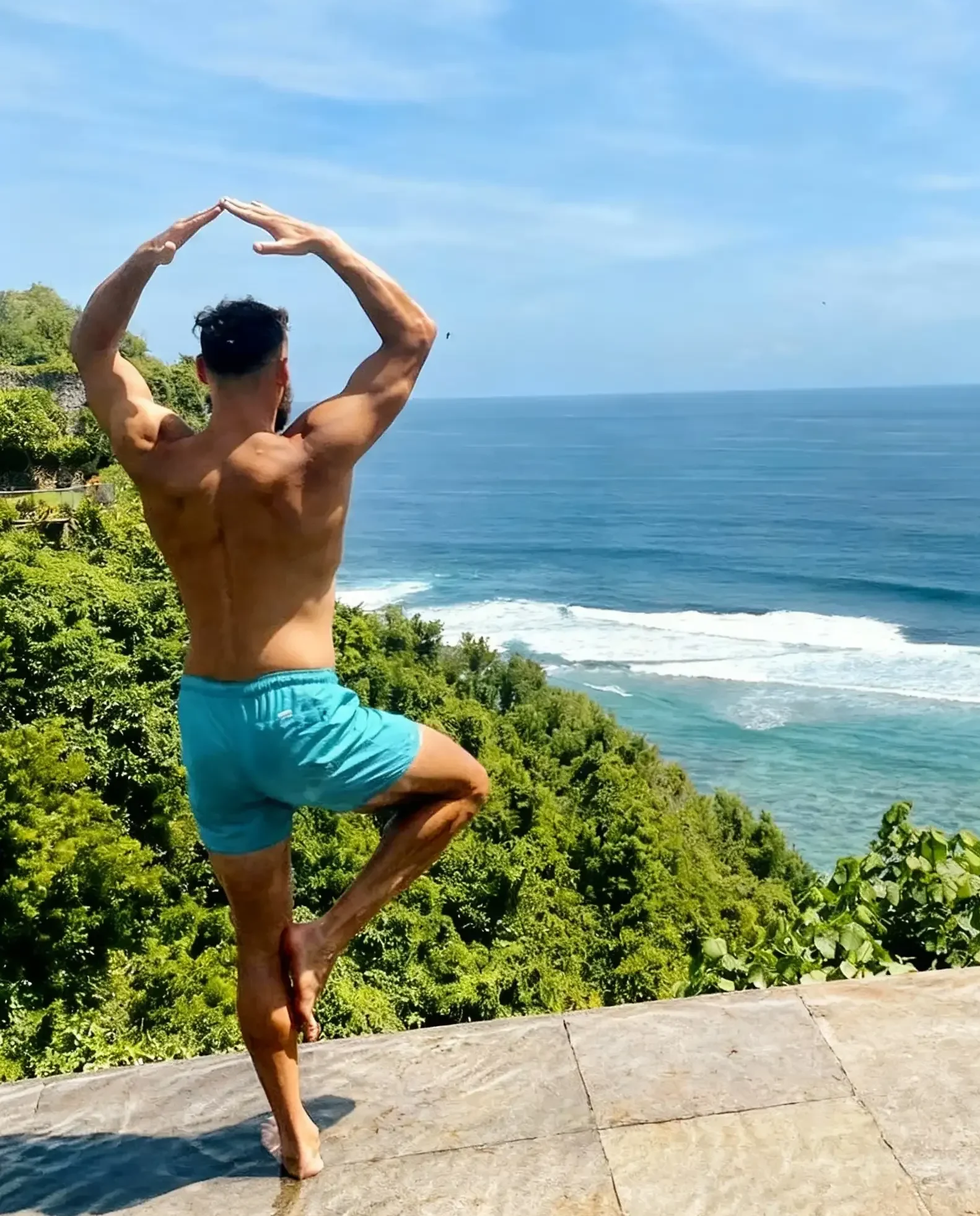 Fitnesstrainer macht Yoga-Übung mit Meerblick - Online Personal Training Online für Mobilität